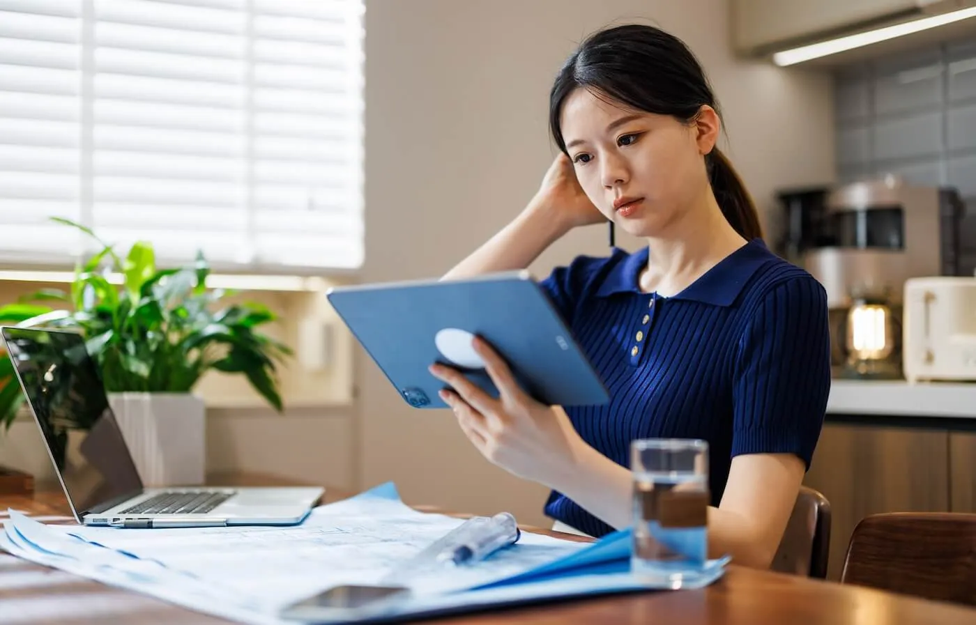 Concerned young woman checking her credit score on a tablet