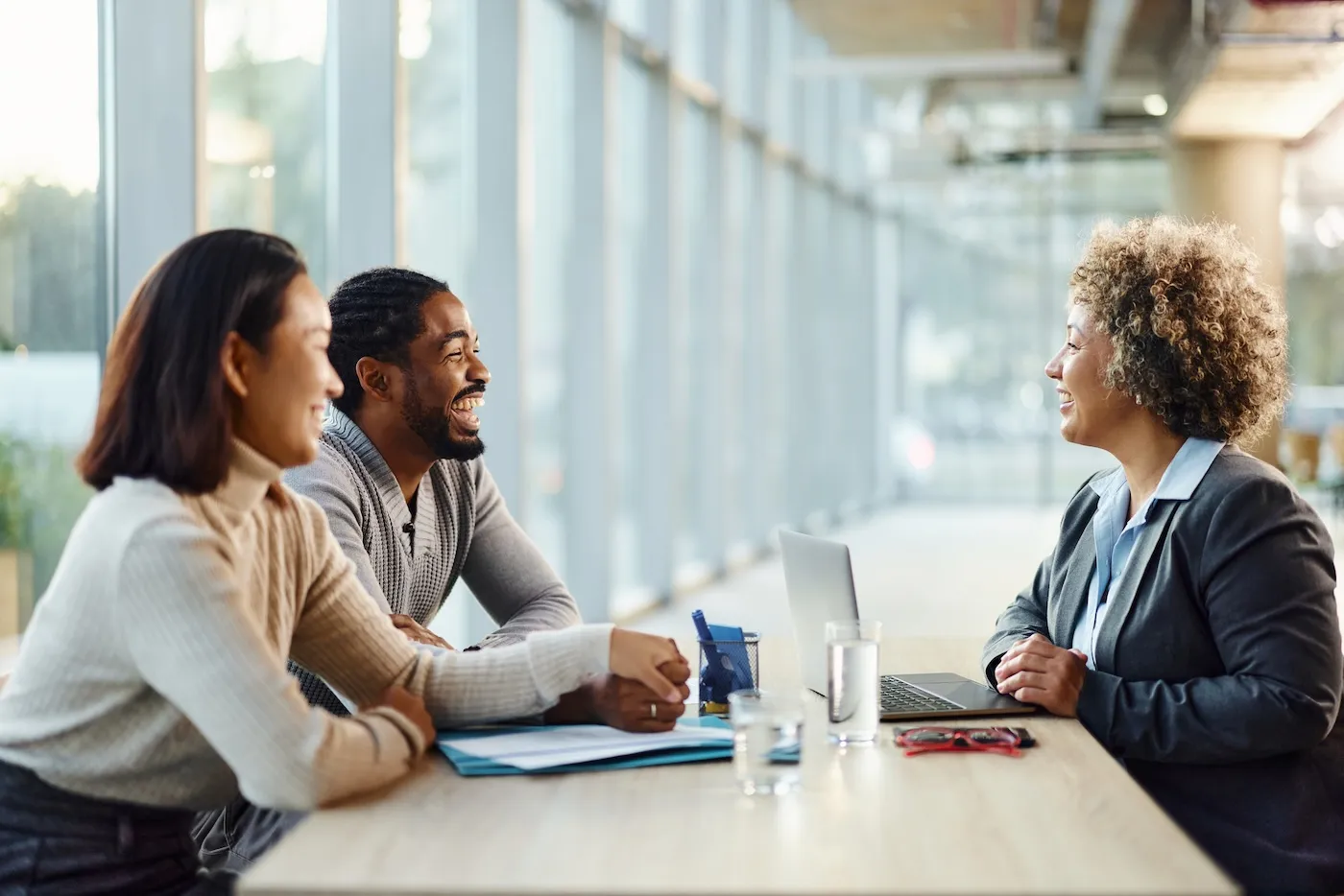 Happy couple communicating with their tax preparer during a meeting in the office.