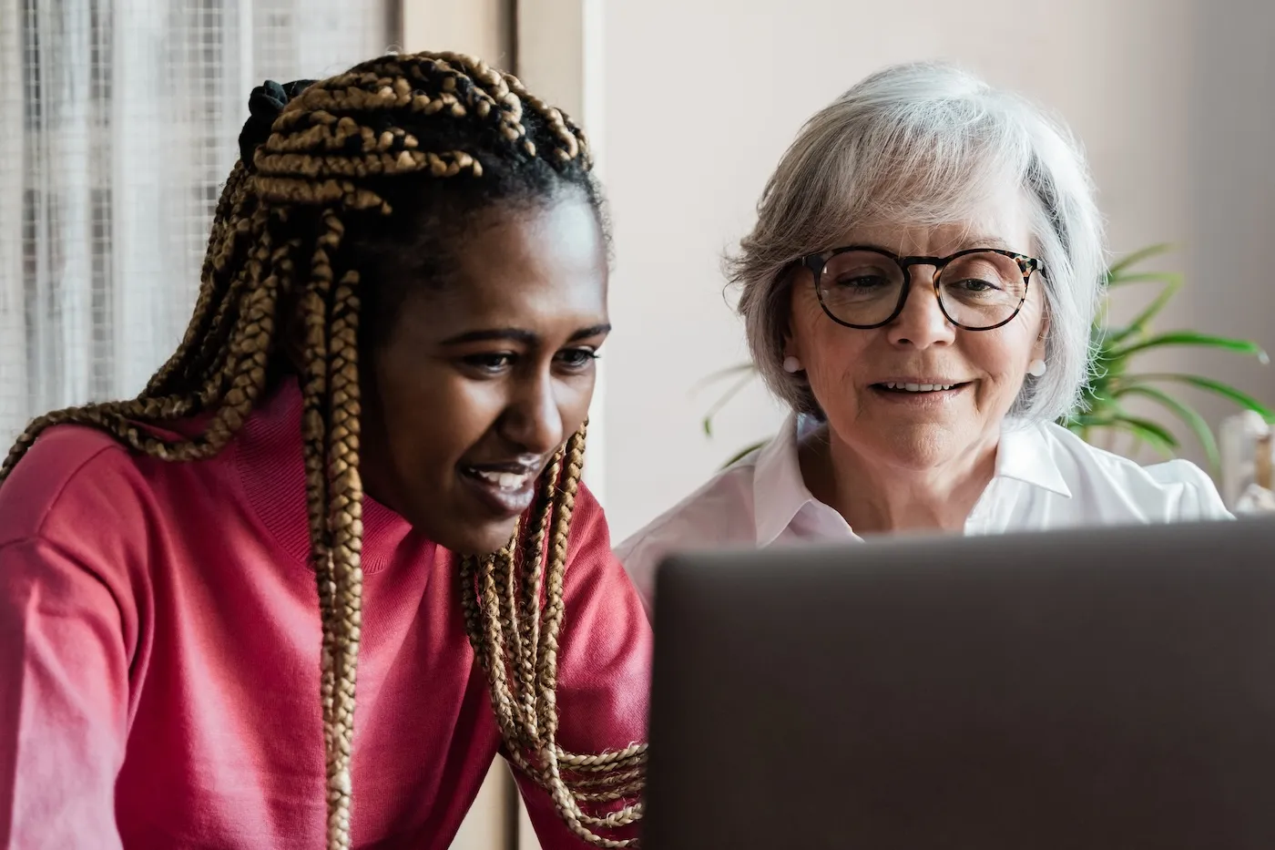 Two women looking at a computer together