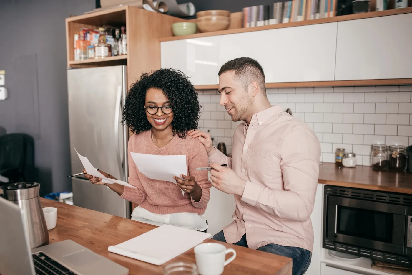 Couple planning their finances on the kitchen counter.