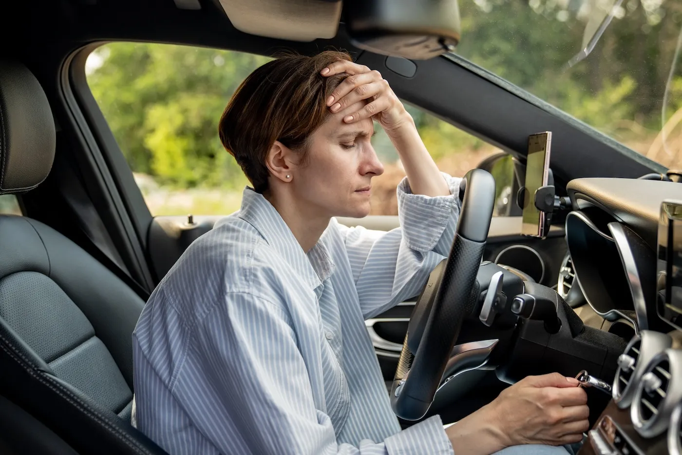 Stressed woman stopped after driving car.