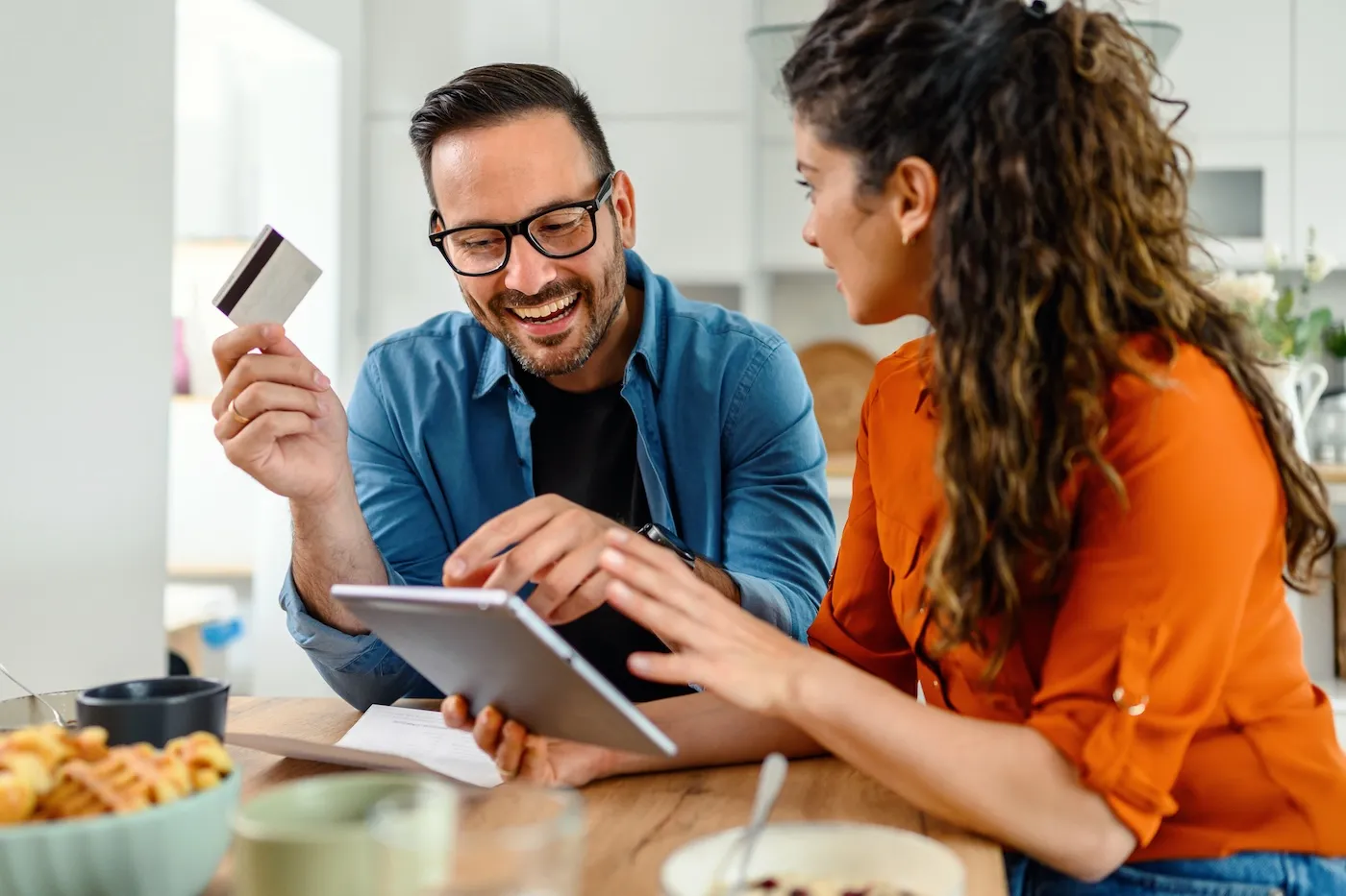 Couple at home paying the bills online using a credit card