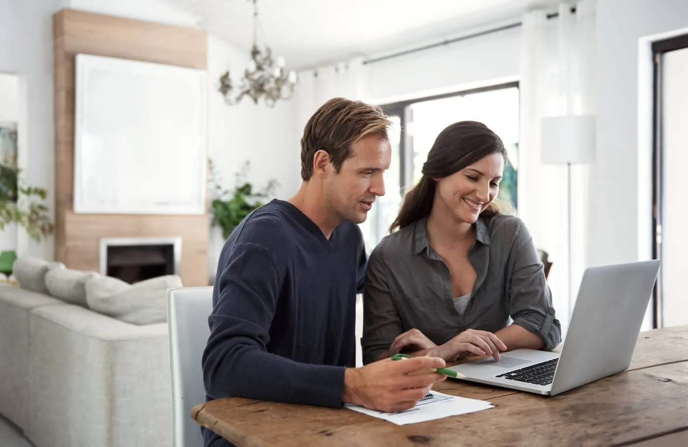 Happy mature couple using a laptop to plan their finances at home