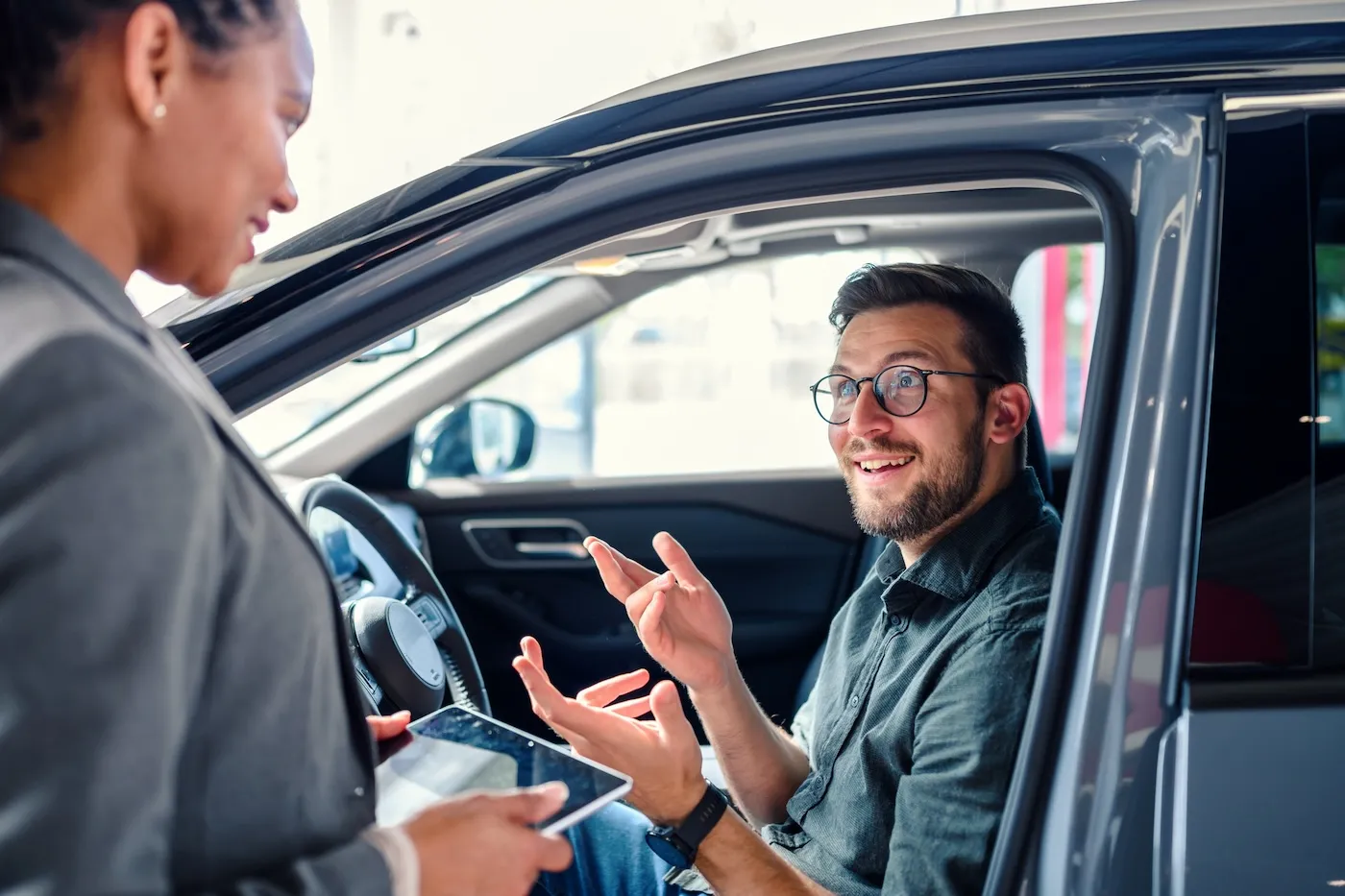 Saleswoman helping the male customer to choose a new car.