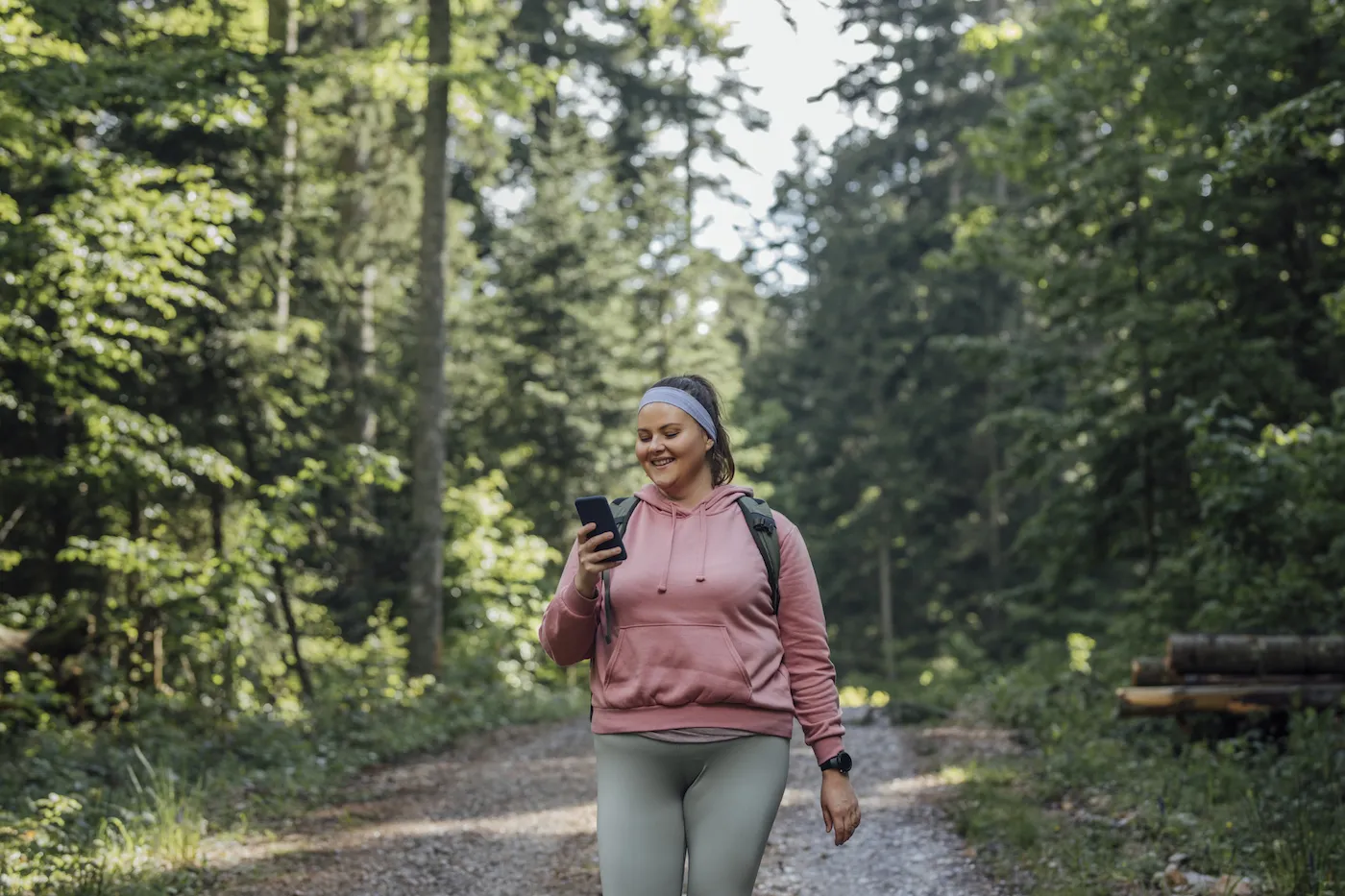 A happy woman spending the day outdoors and walking with her smart phone.