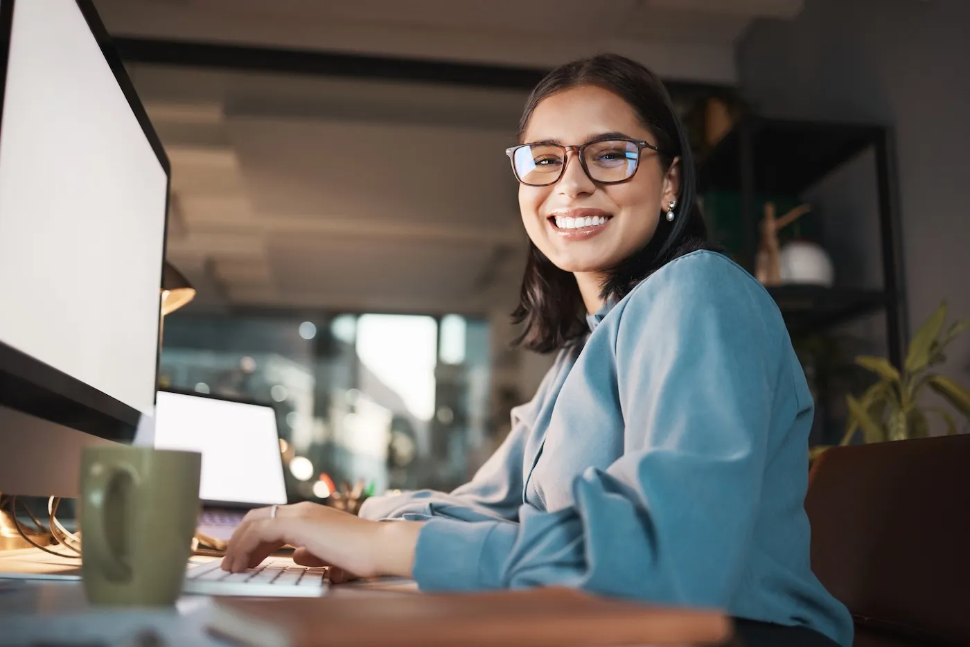 Portrait of woman in office working at her desk on the computer.