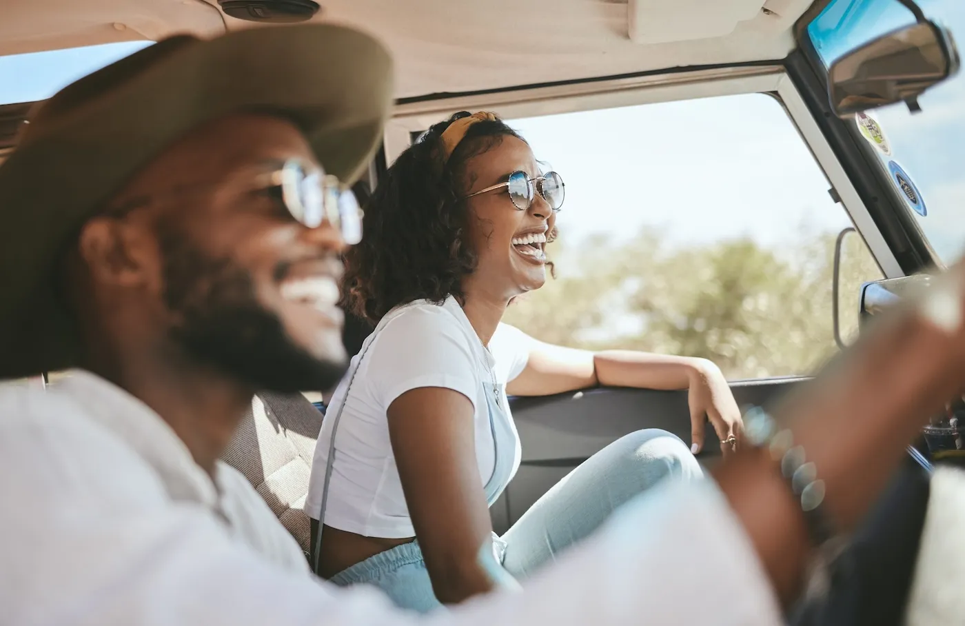 A road tripping couple driving by countryside for holiday.