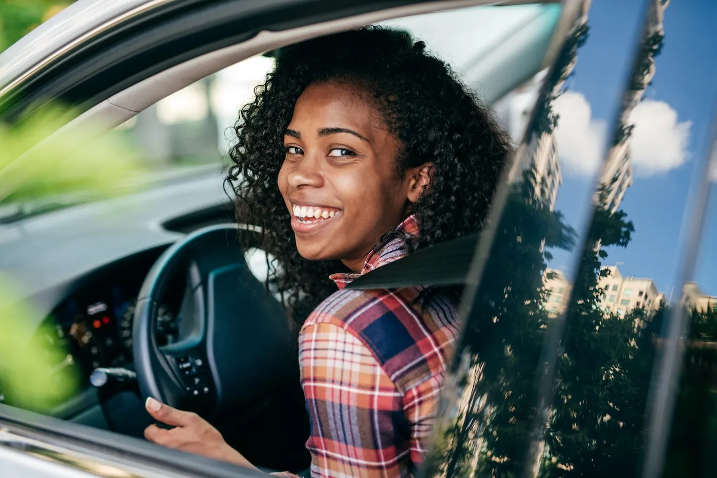 A happy student driving a car.