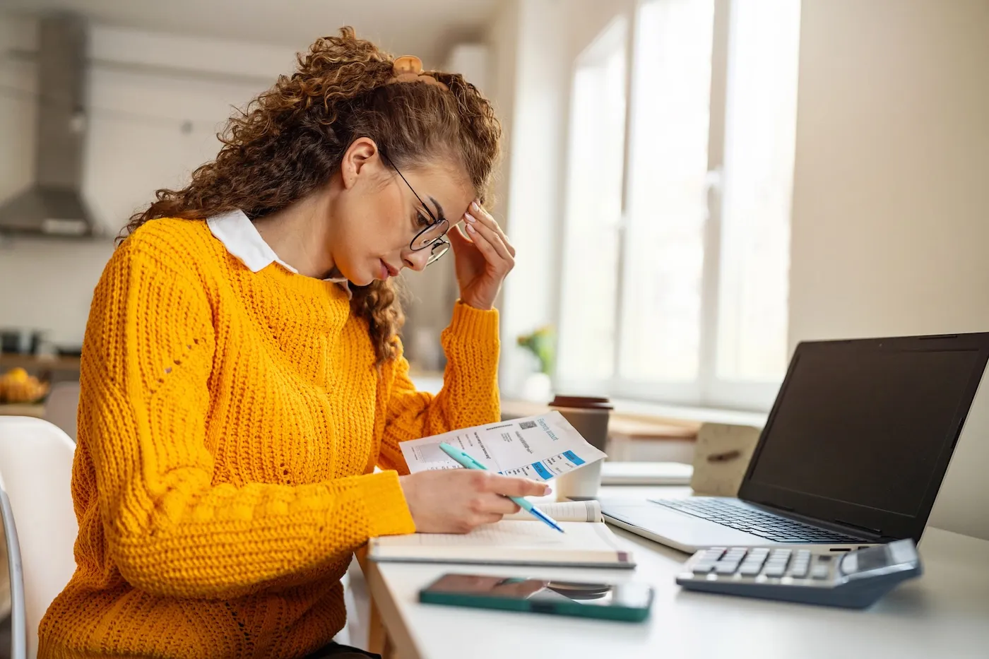 A worried young woman, organizing home finances.