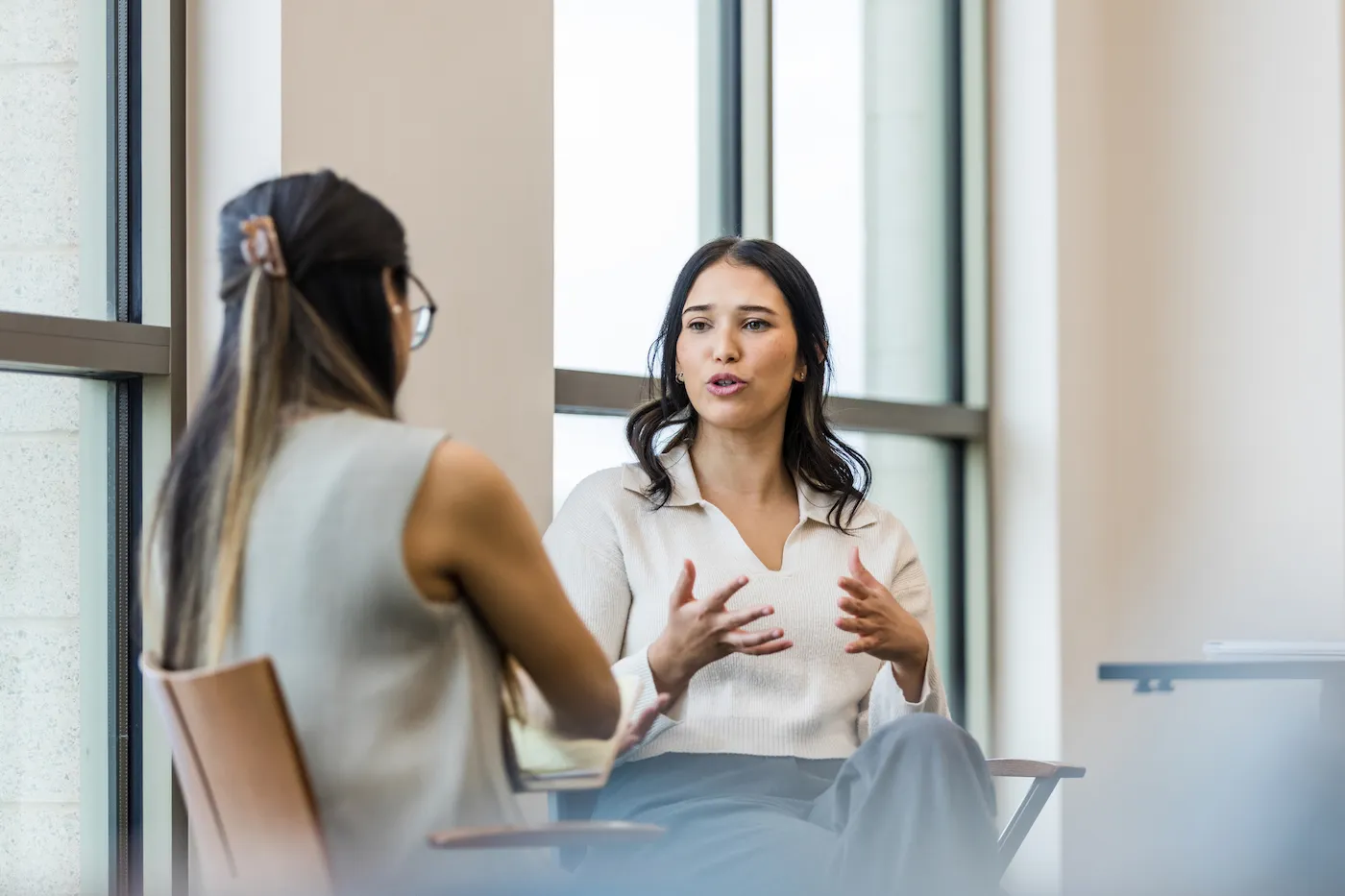 Two women sitting together and having a conversation about money.