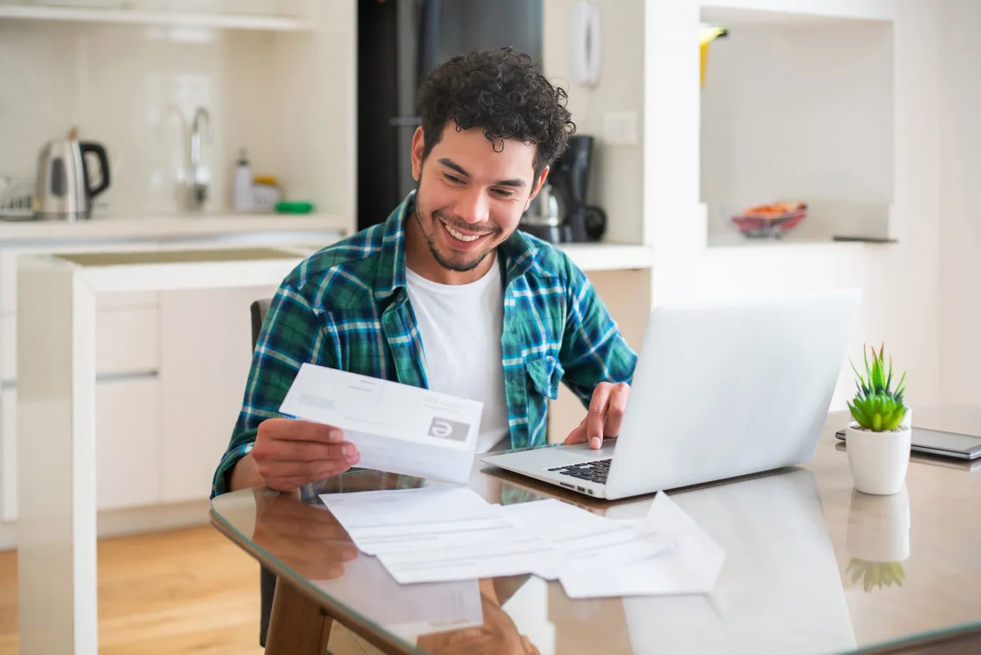 Happy man paying his utility bills online from home.