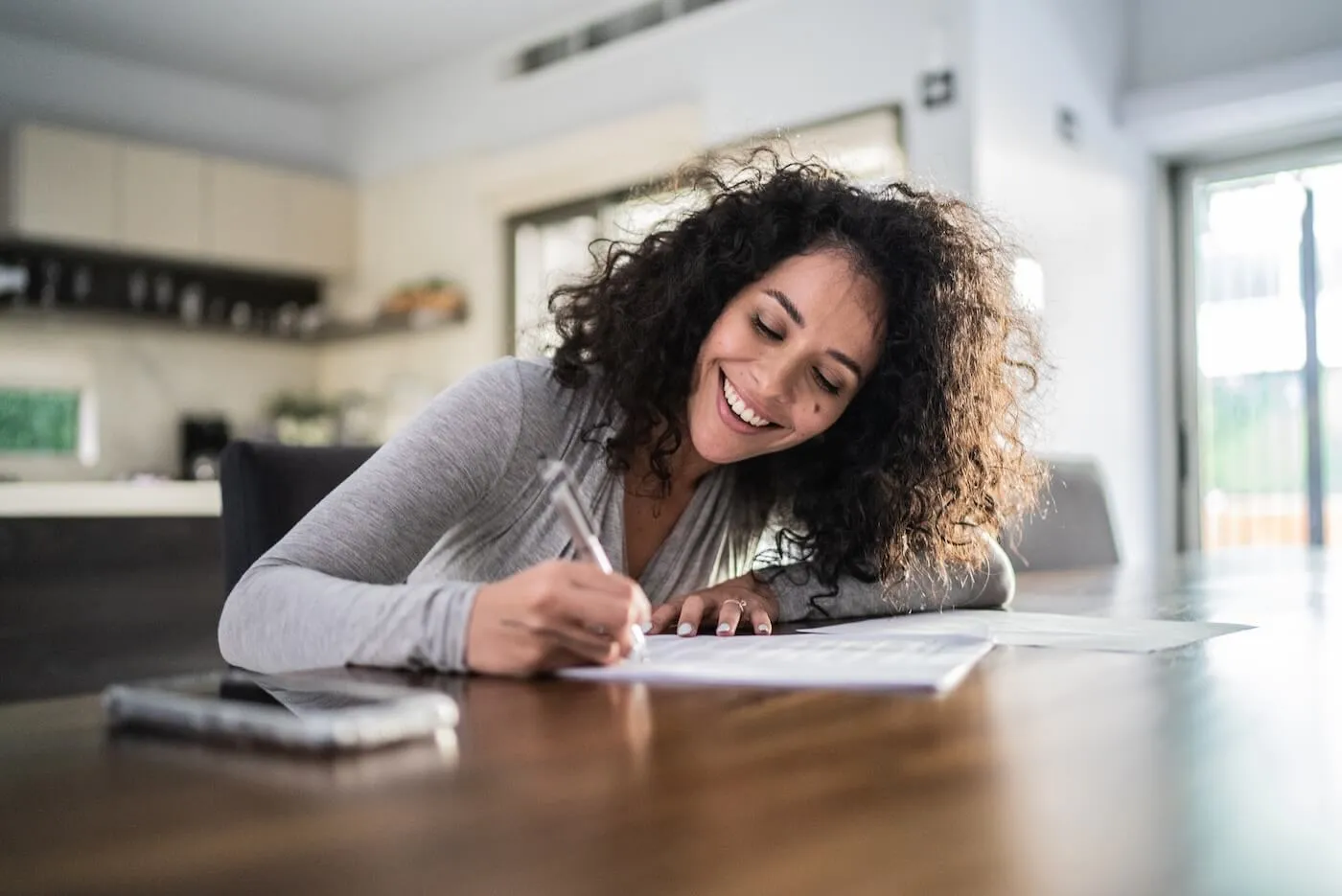 Smiling woman is planning her debt pay off in a home office