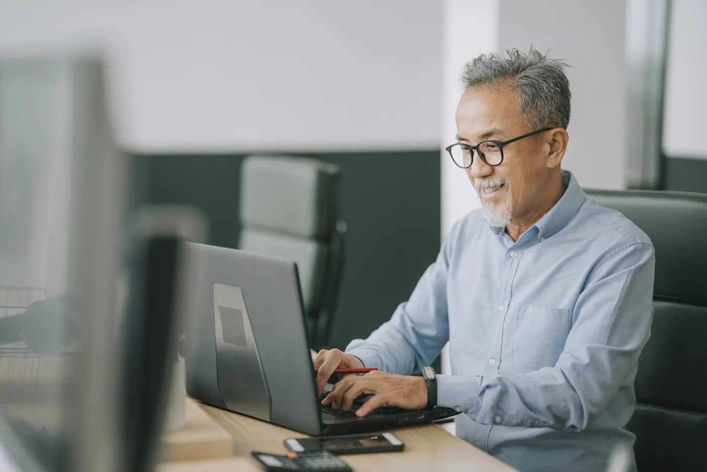 A senior man with facial hair using laptop to check his credit score.