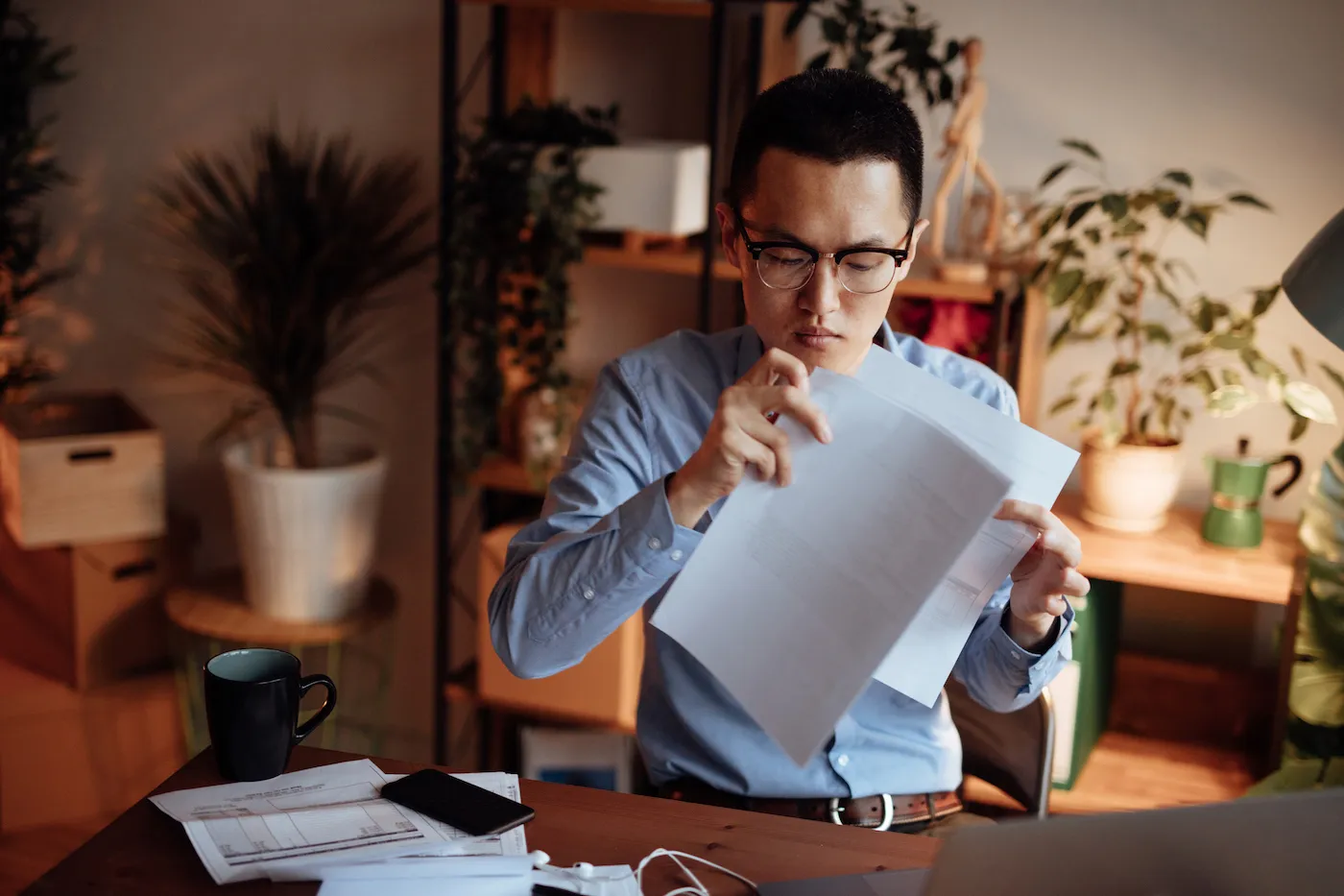 Man reading credit card statement in his home office