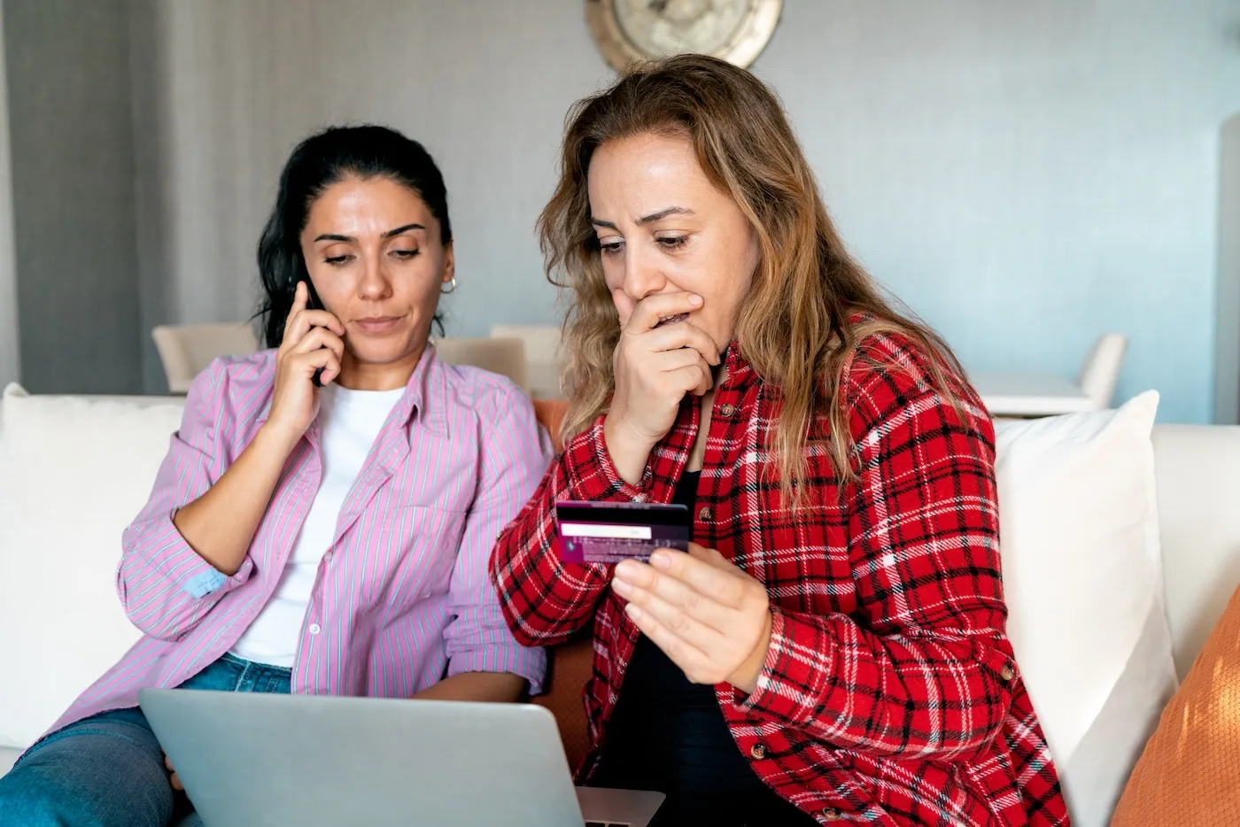 A woman holding bank card and being surprised