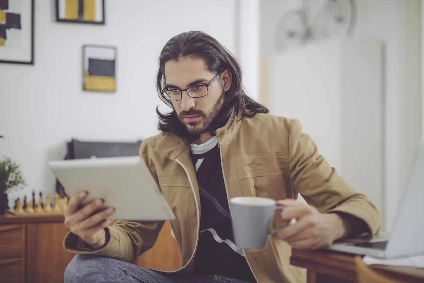 Young man looking at credit report on a tablet at home.