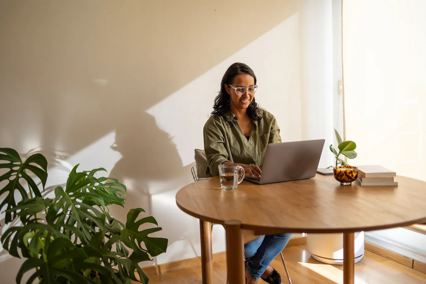 Woman sitting in the sunny living room. She is working from home today