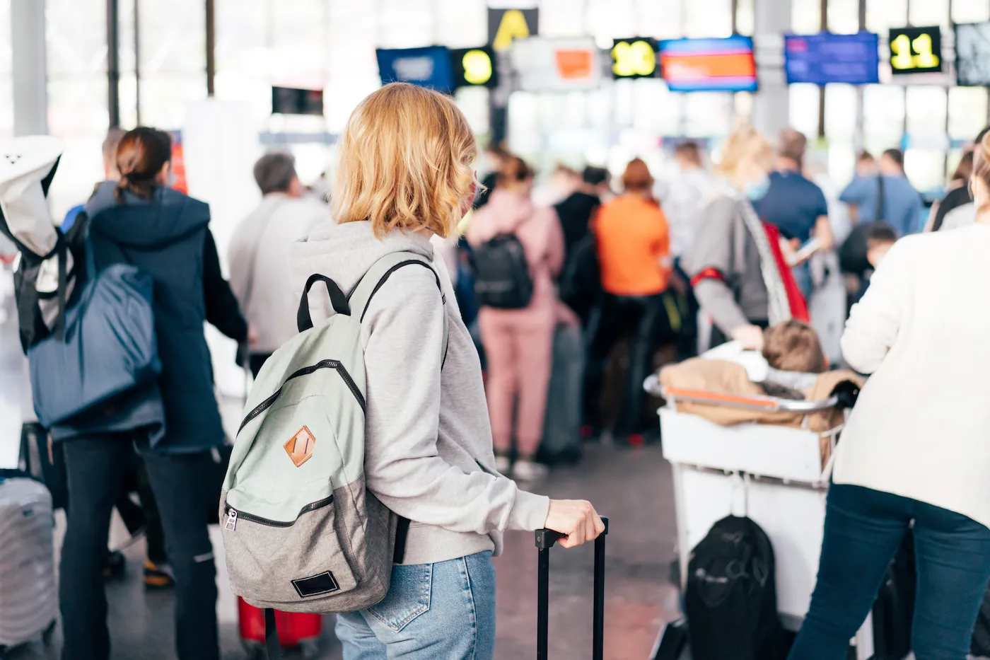 Unrecognizable people, a view from the back, a queue at the airport for check-in.