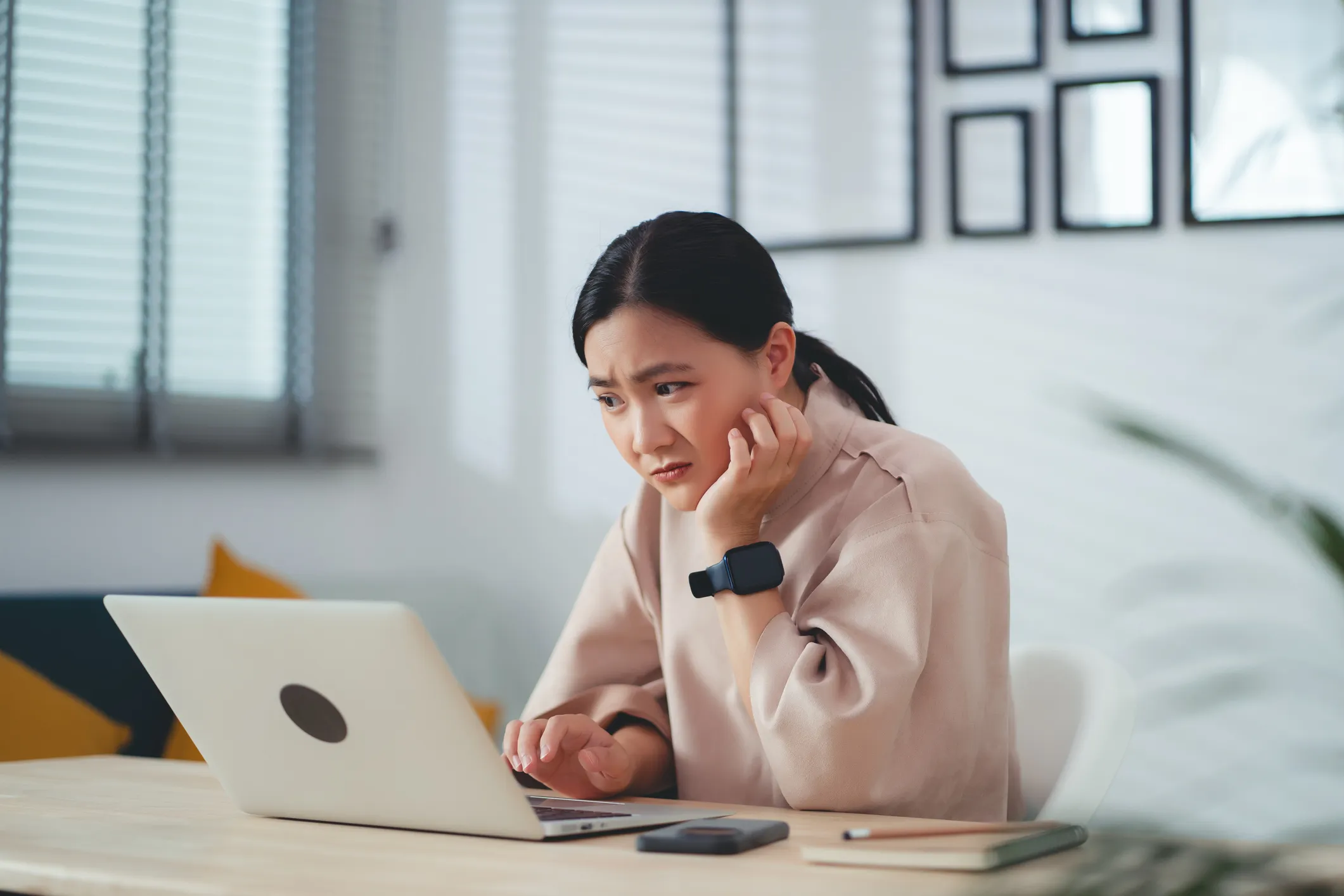 Concerned woman using her laptop in the office