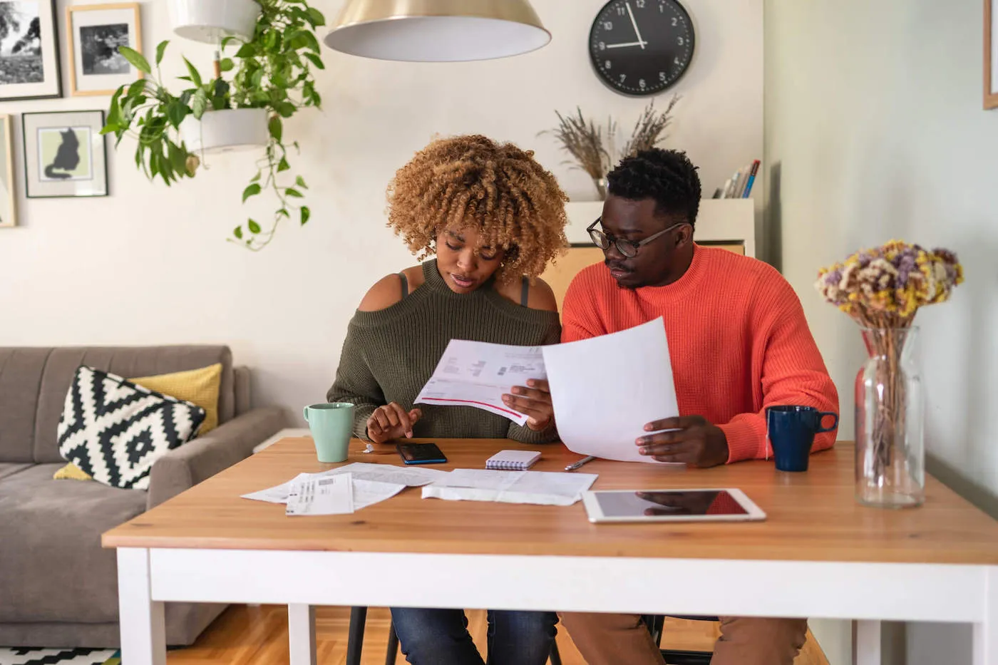 Man and woman couple seated at living room desk pouring over accounts.