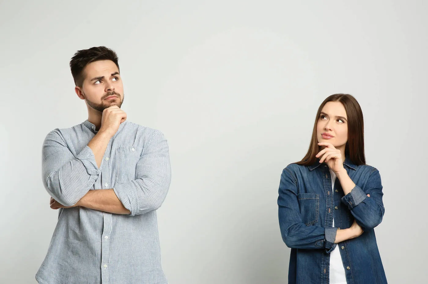 Man and woman pensive with arms crossed.