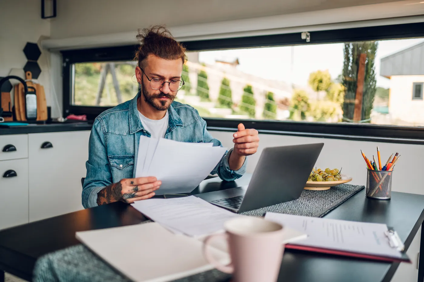 A man sitting at a table reviewing debt consolidation paperwork.