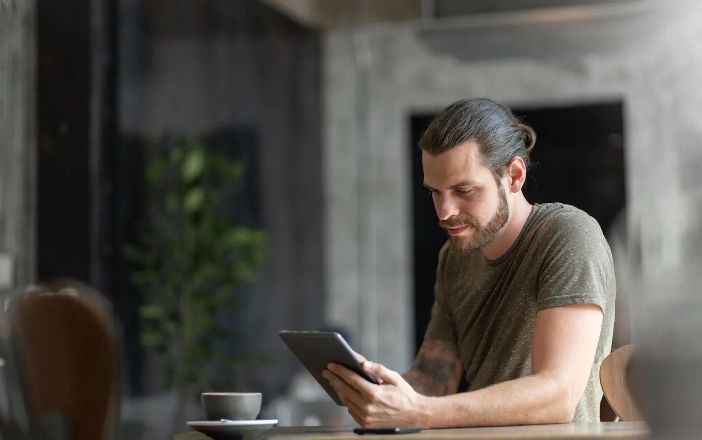 Man sitting using digital tablet at the coffee shop.