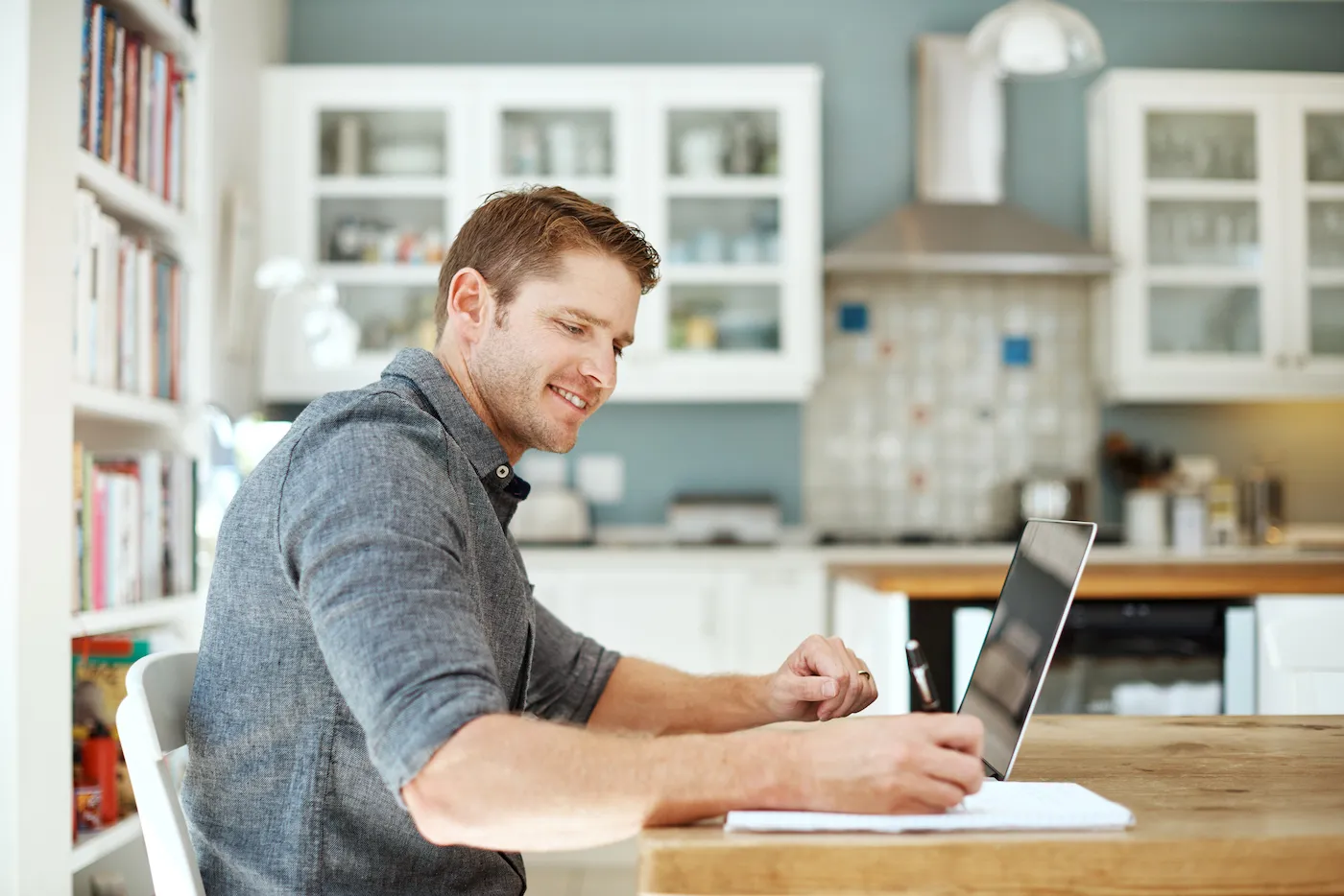 Shot of a young man using a laptop to track the progress of his savings account.