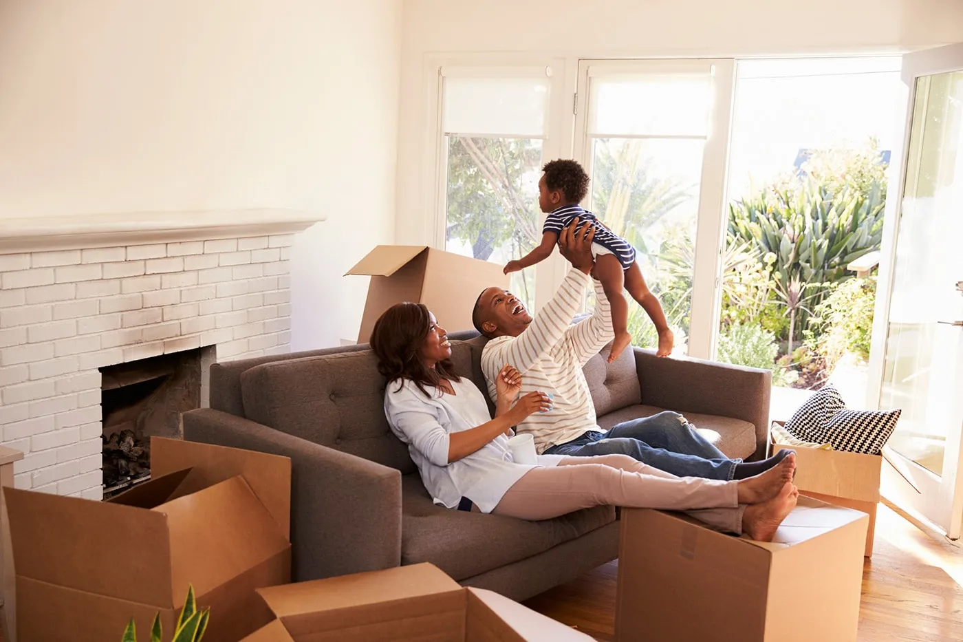 couple bounce baby while lying on sofa in a new home