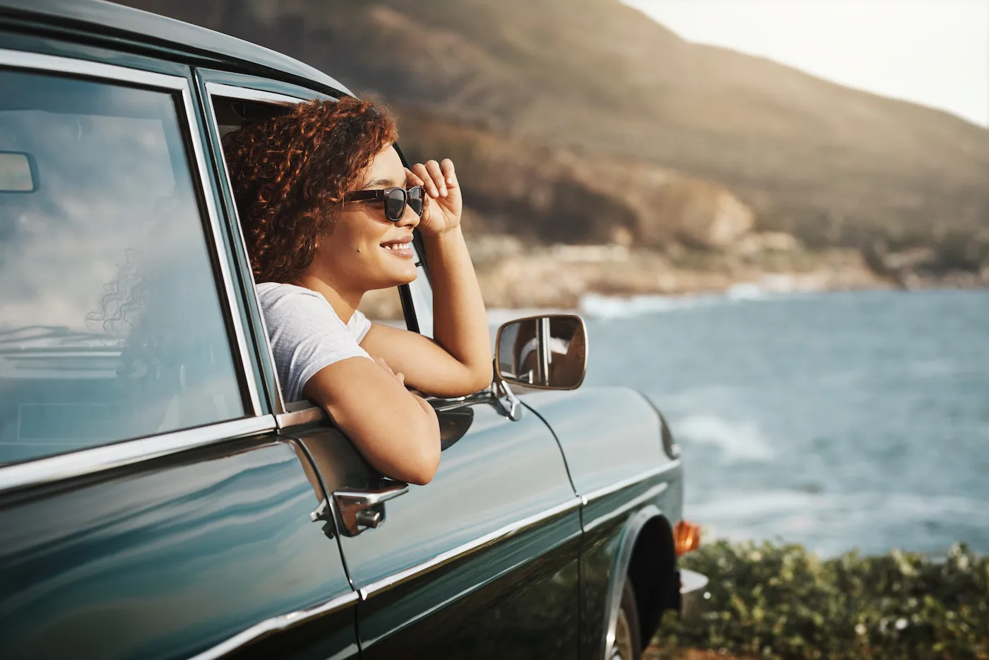 Shot of a young woman enjoying a road trip