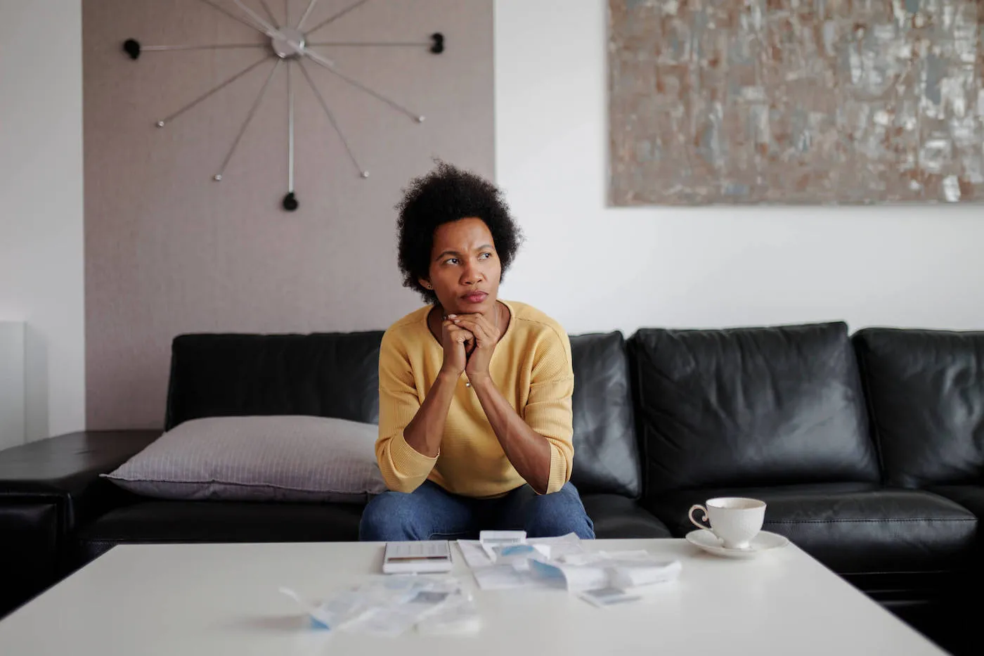 Seated African American woman in deep thought while financial decision.