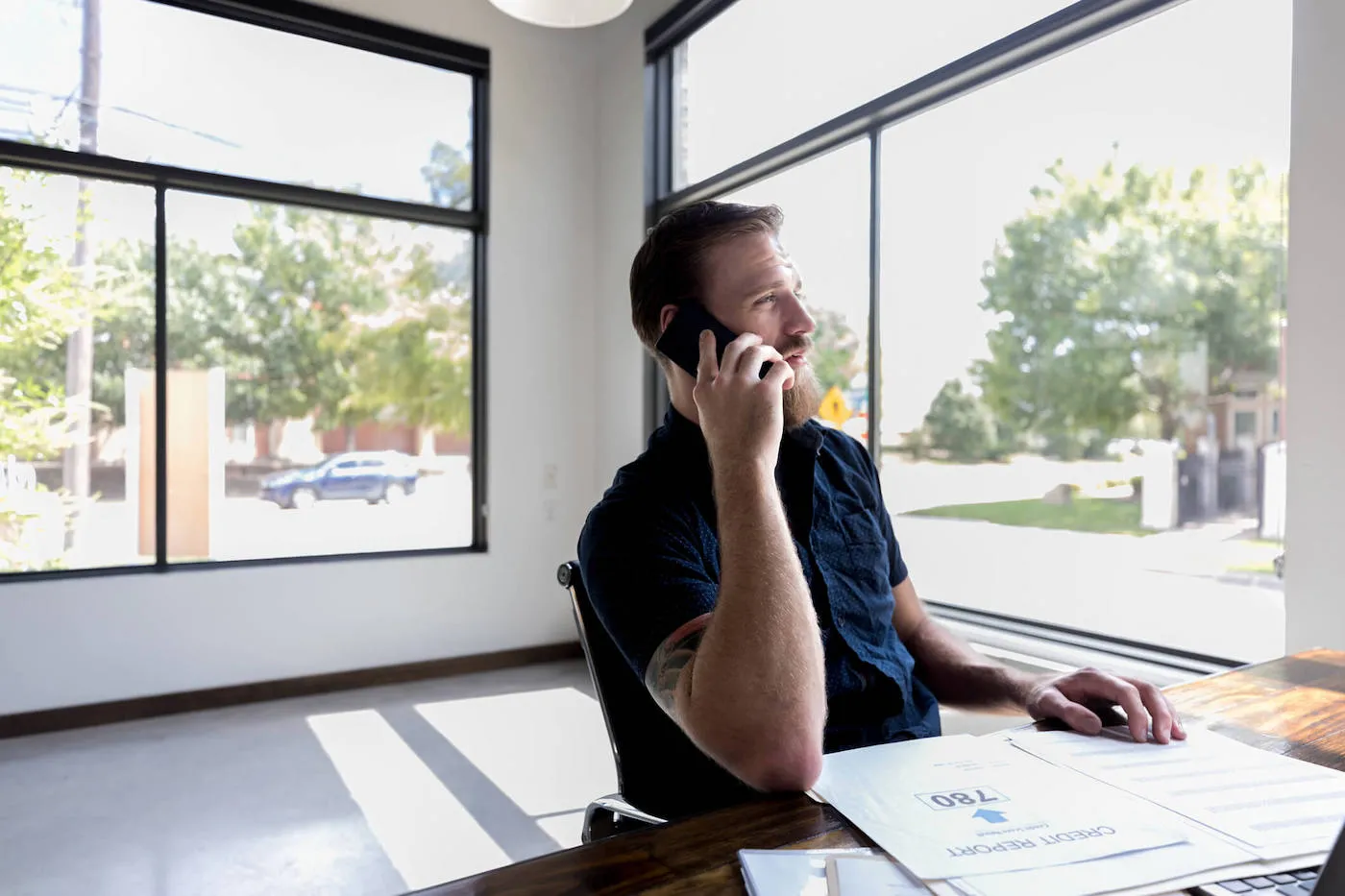 Seated man on phone checking credit report.