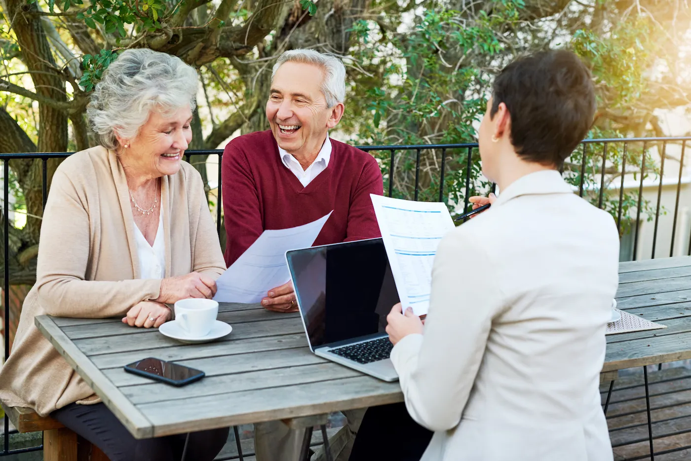 senior couple meeting with their life insurance agent at a table outside