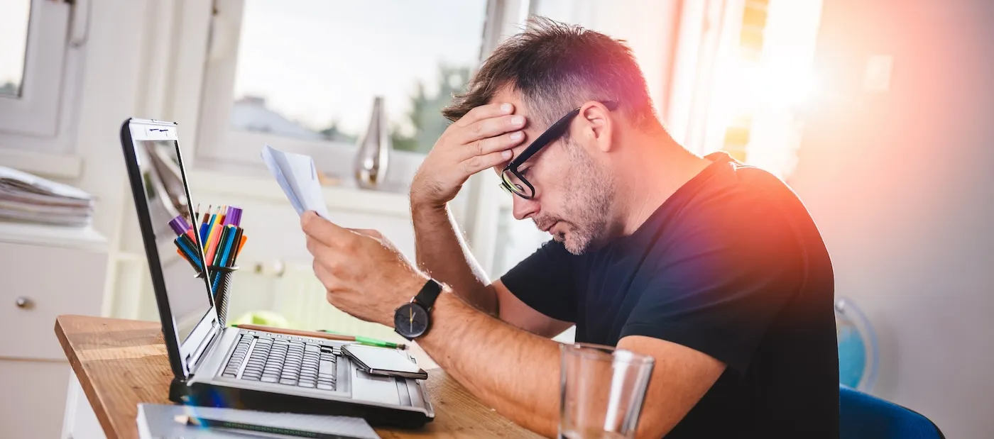 Man sitting in home office, reading letter and felling worried.