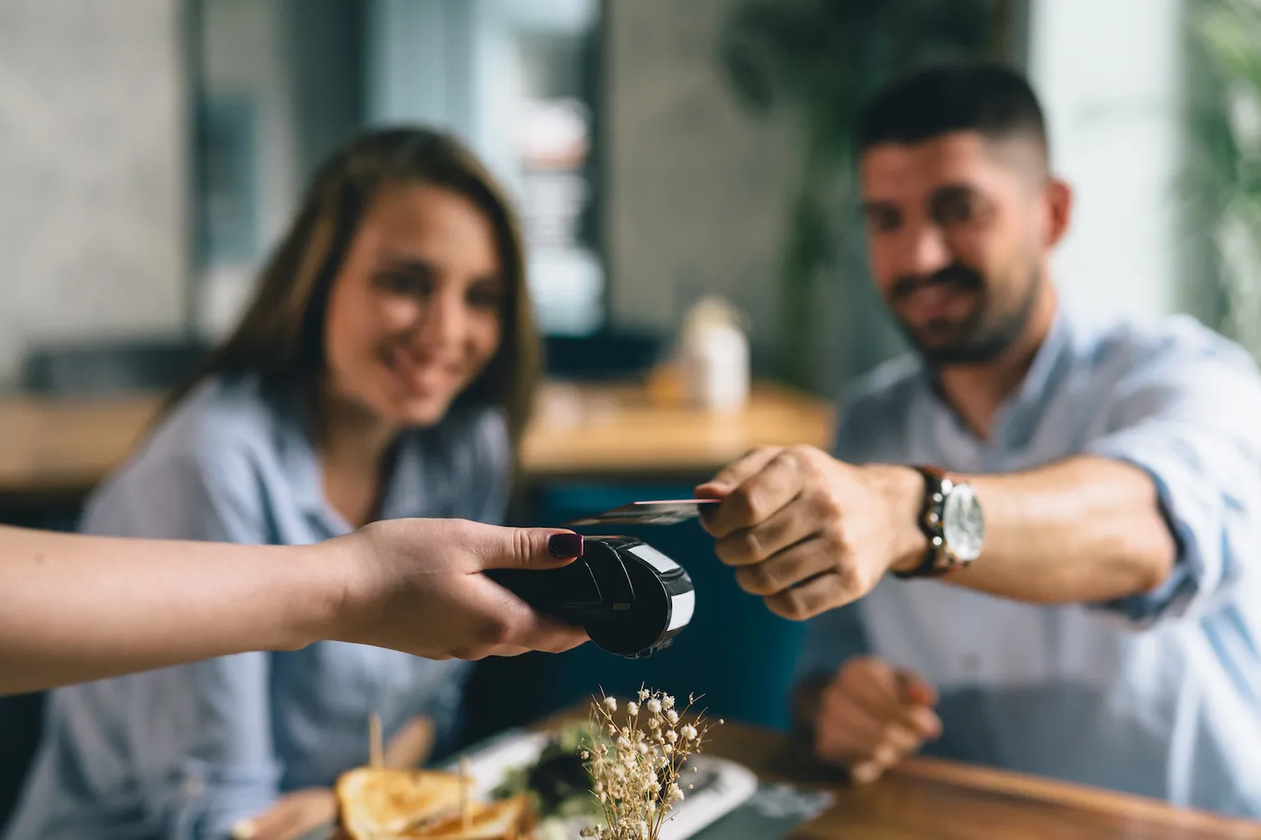 man making payment with credit card in restaurant