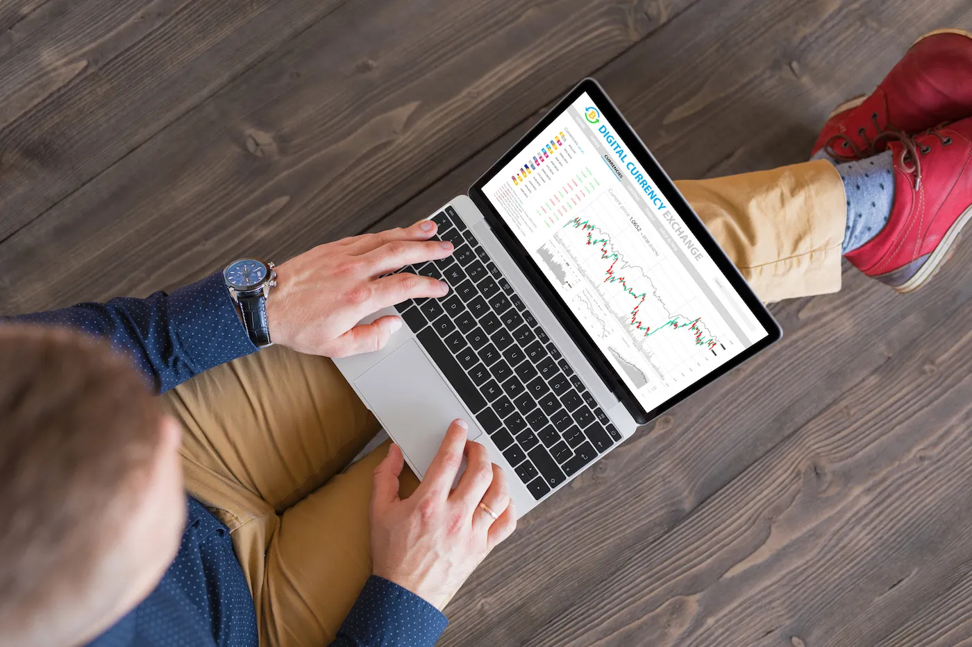 Top down view of man looking at investments on laptop