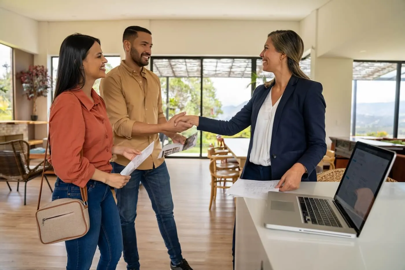 Couple shaking hands with real estate agent before signing a second mortgage agreement