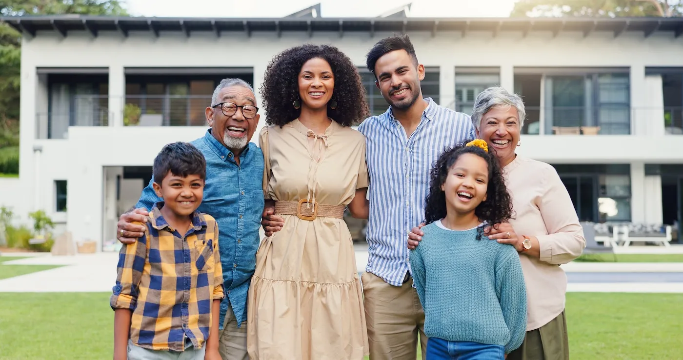 A happy family standing on the lawn of their mansion.