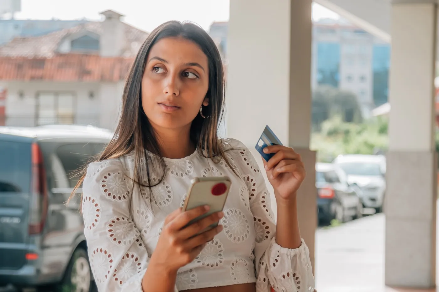 A woman holding her mobile phone and credit card.