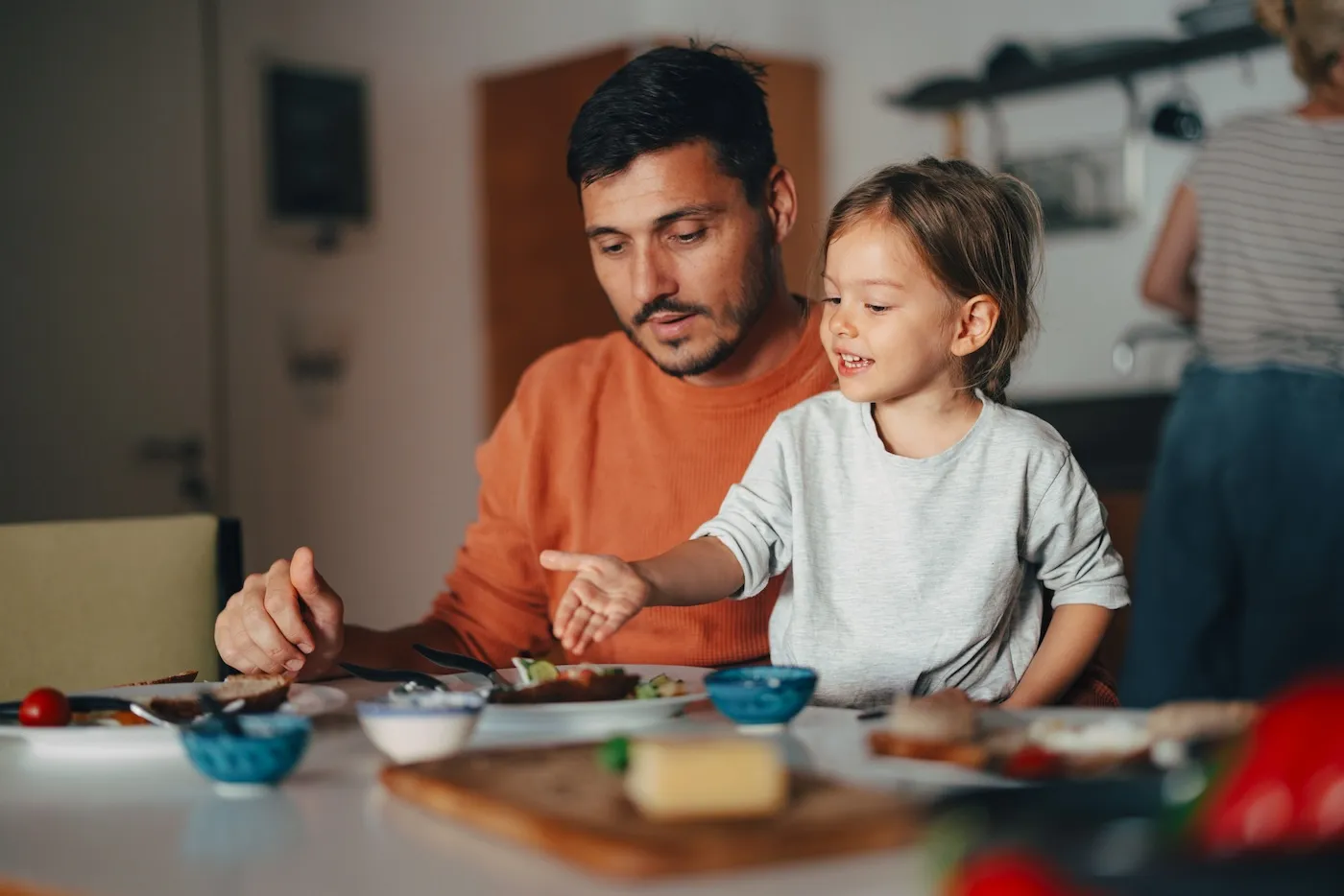 A child having a meal together with her family.