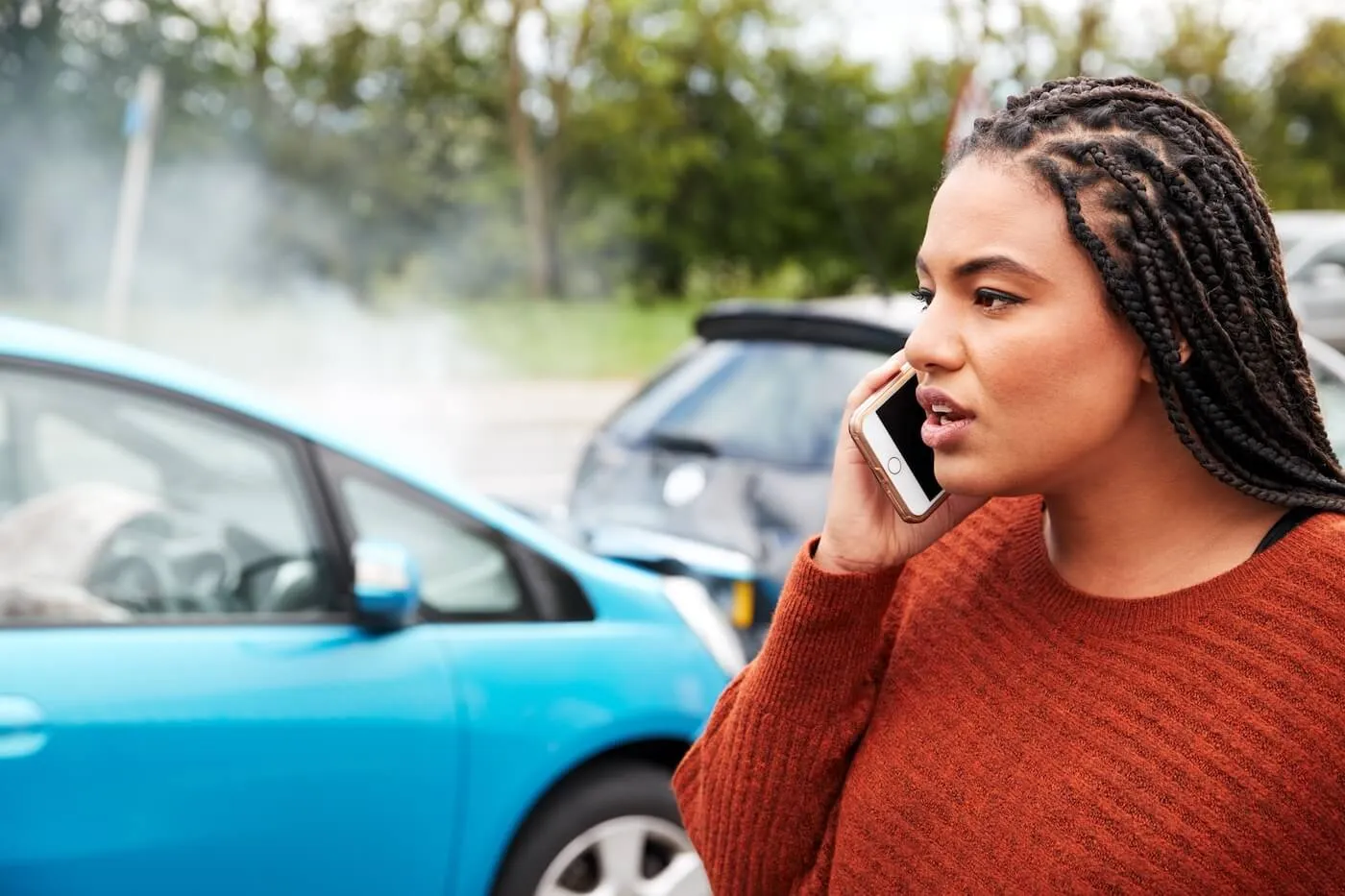 Woman is making a call to the insurance company after the car accident