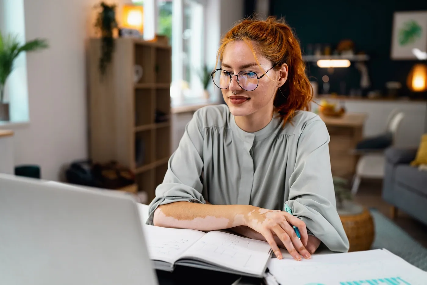 Young woman using laptop while studying from home.