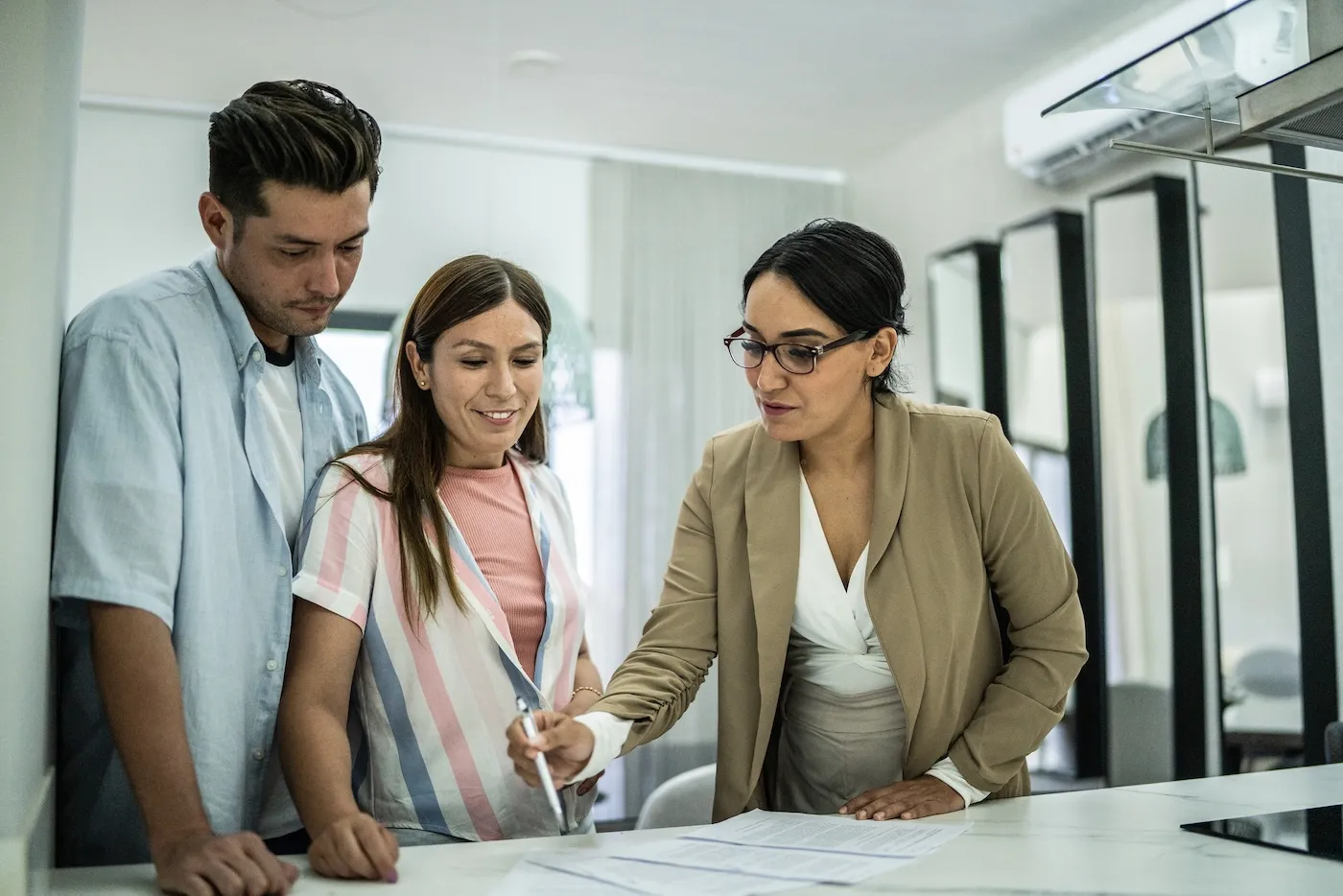 Mid adult couple signing documents at home