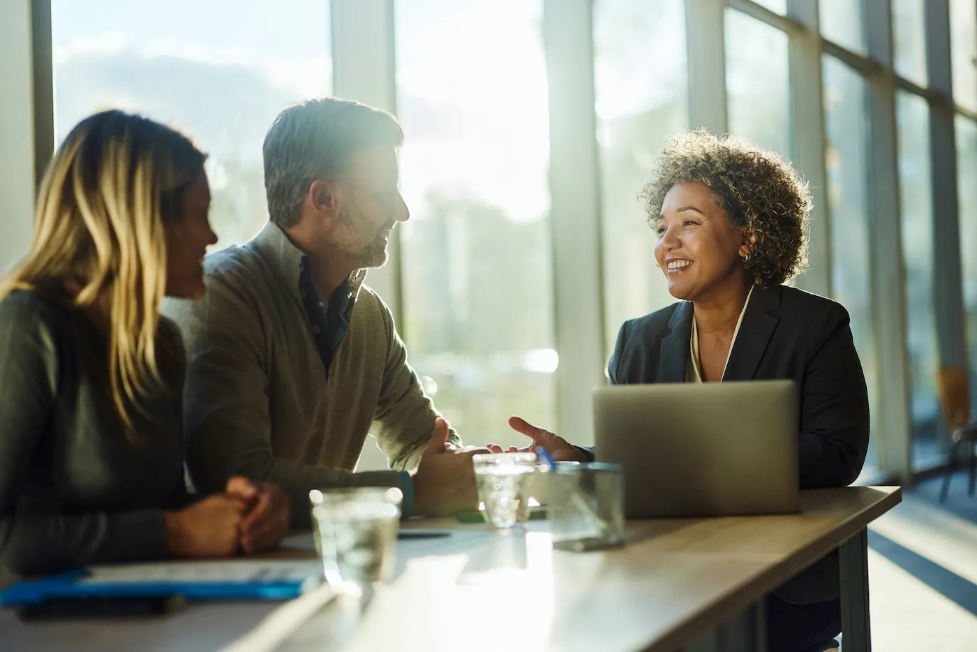 Happy female professional communicating with a couple during a meeting in the office.