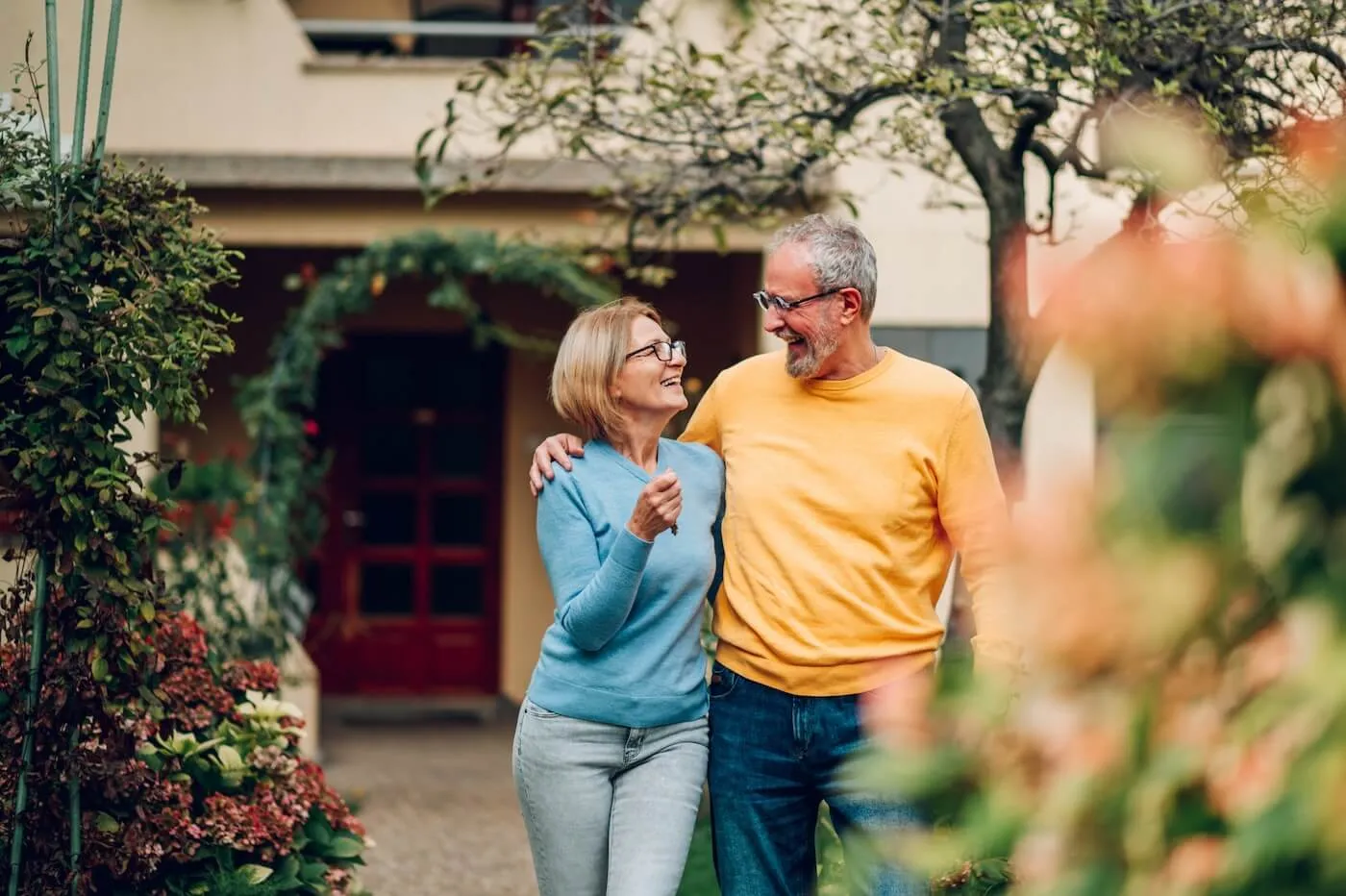 A happy senior couple walking through the front yard