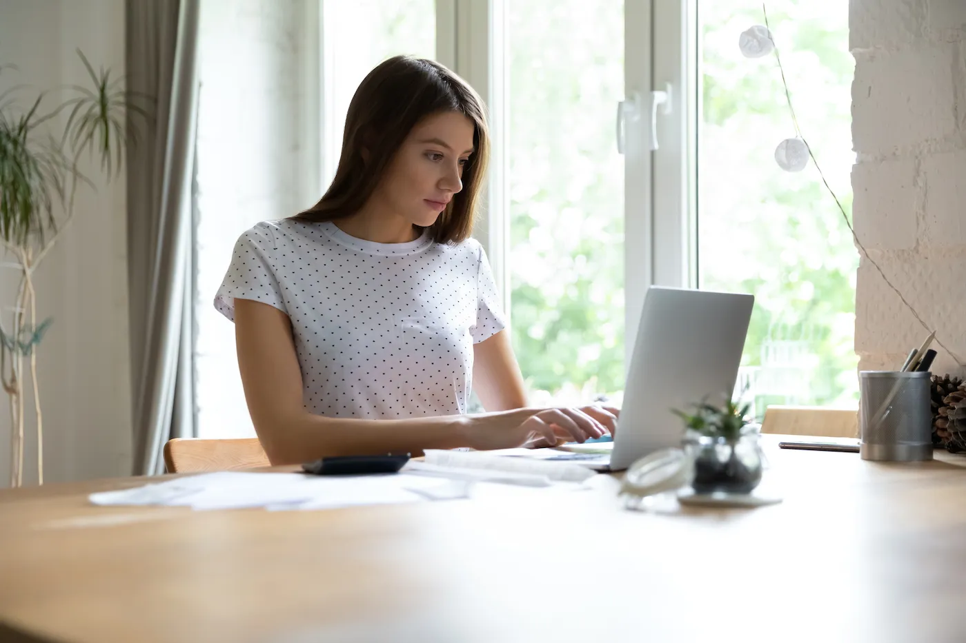 Focused young woman checking financial documents, repayment plan.