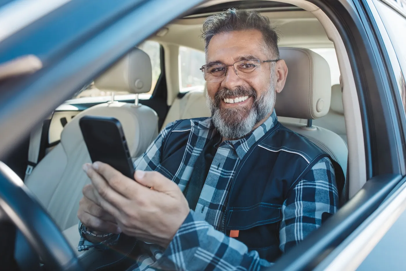 A man in car using smartphone.