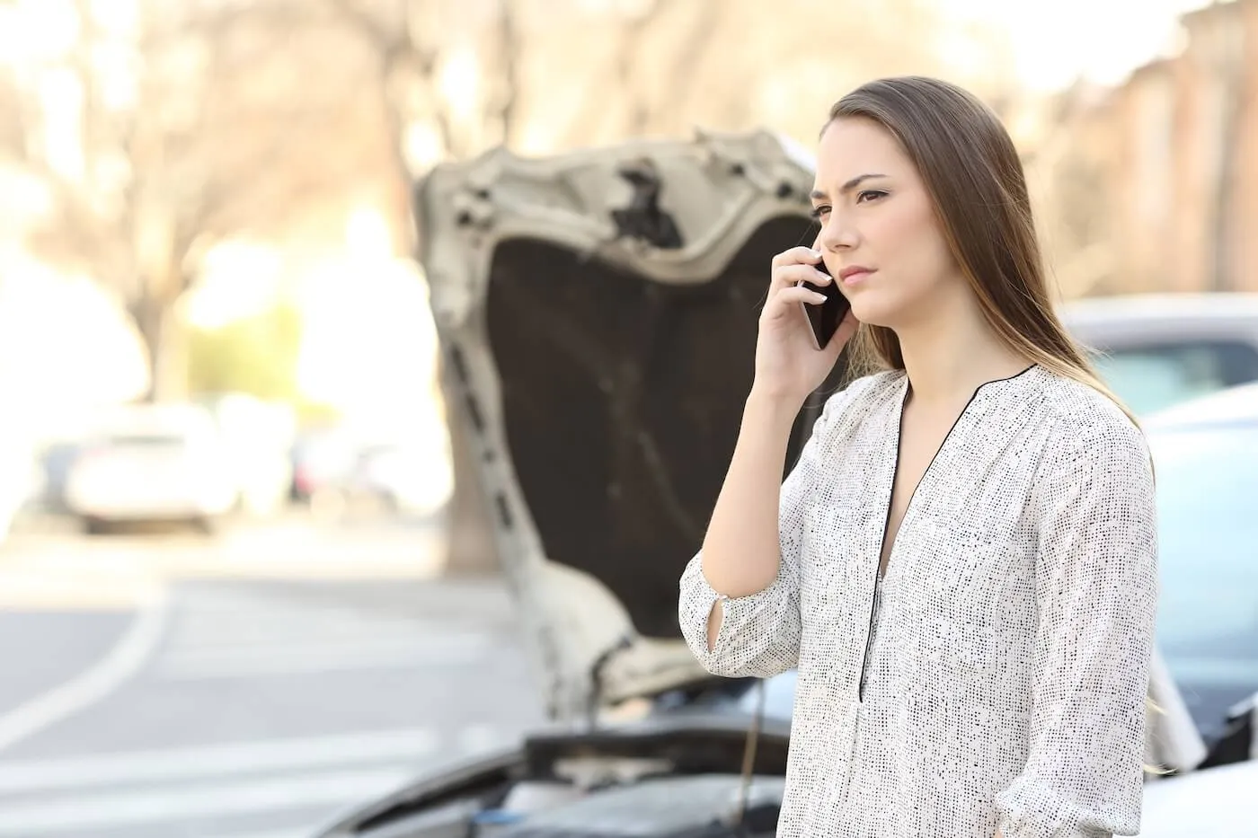 Concerned woman is calling to the insurance company after a minor car accident