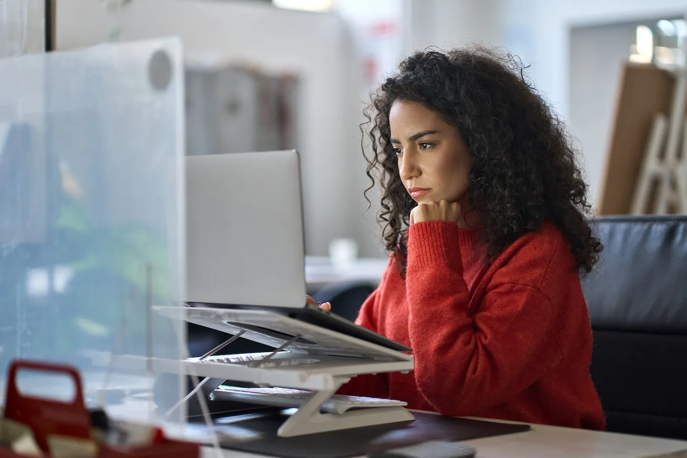 Busy worker working on laptop thinking about high yield savings account rates.