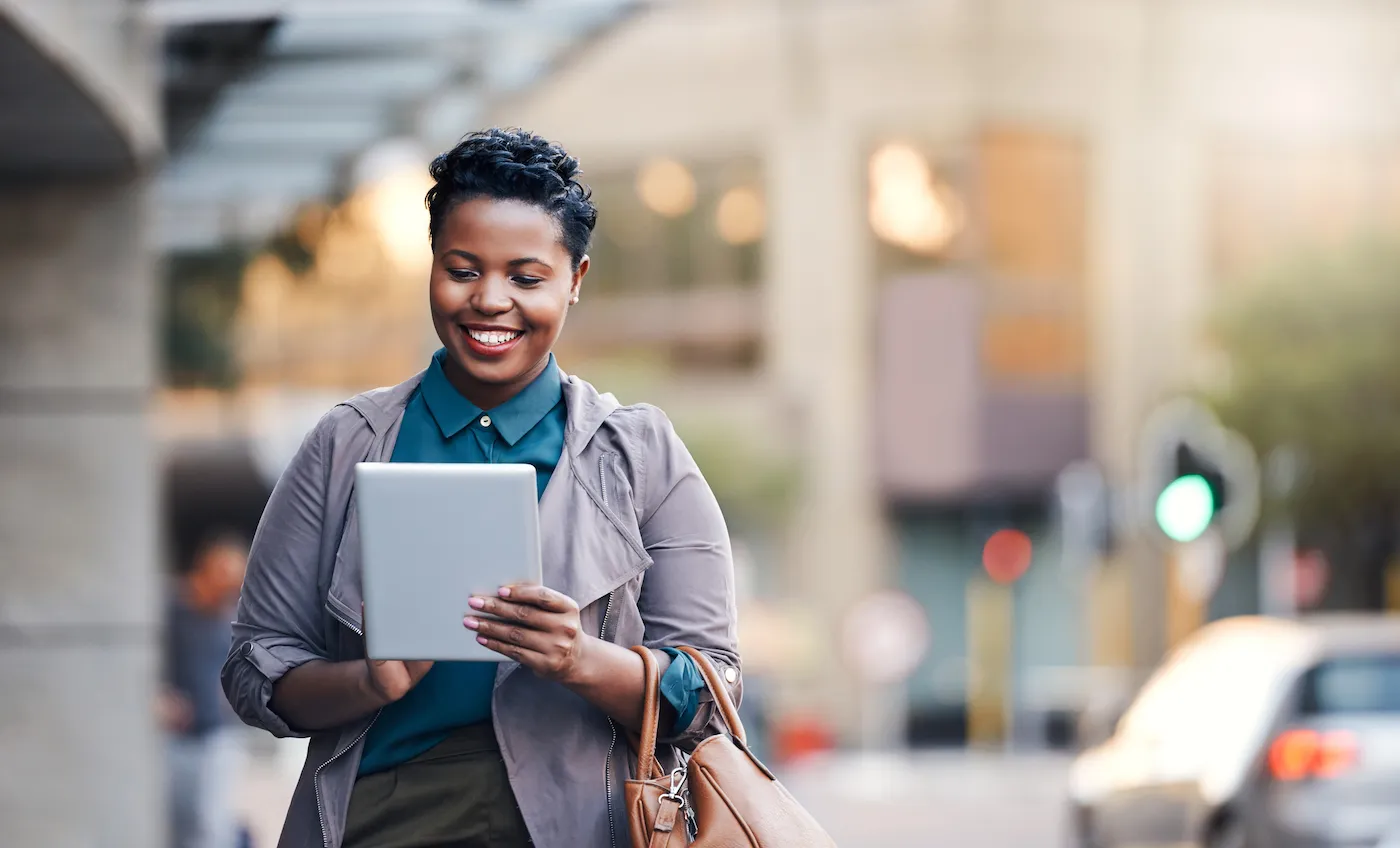 Shot of a young businesswoman in the city checking her high yield savings account on her tablet